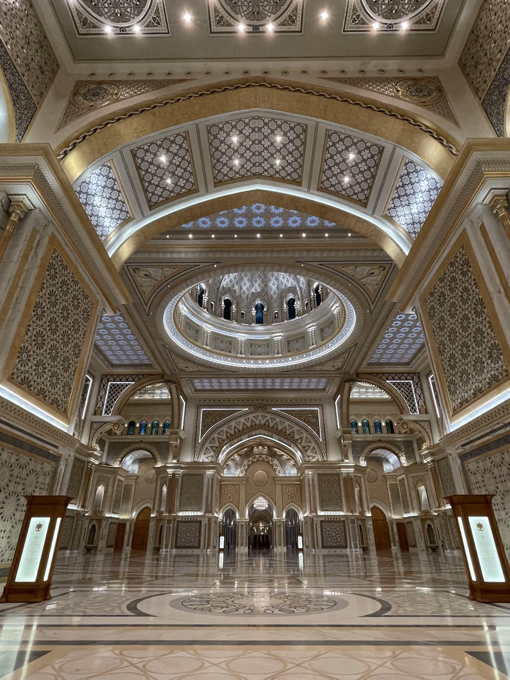 Ornate interior architecture featuring a massive golden dome and intricate marble designs inside Qasr Al Watan in Abu Dhabi.