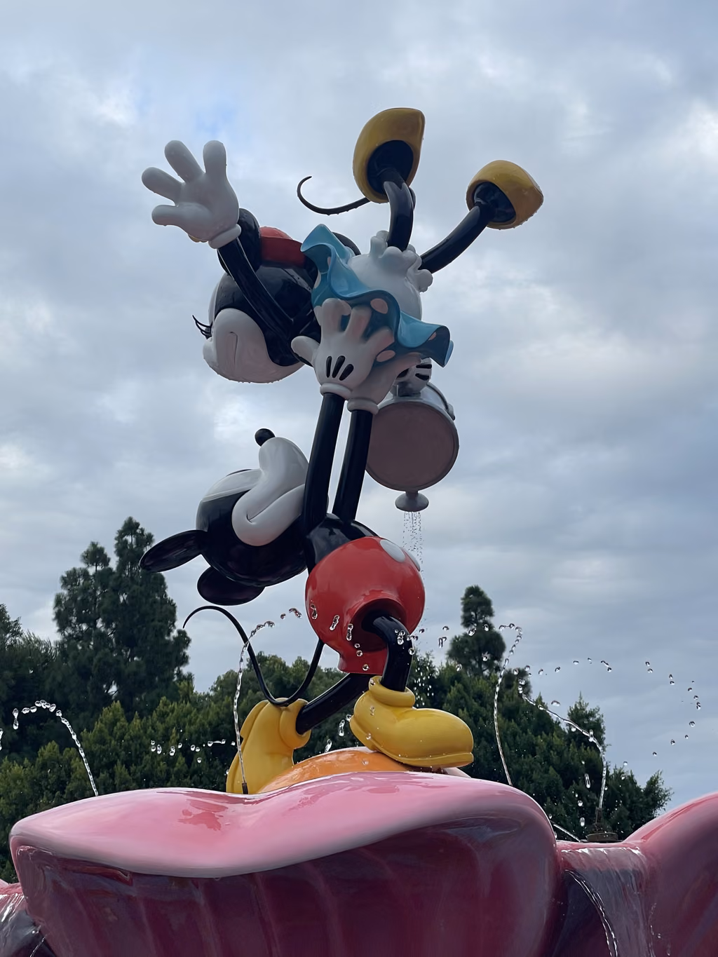 A colorful statue of Mickey and Minnie Mouse splashing in a fountain at Disney's Grand Californian Hotel.