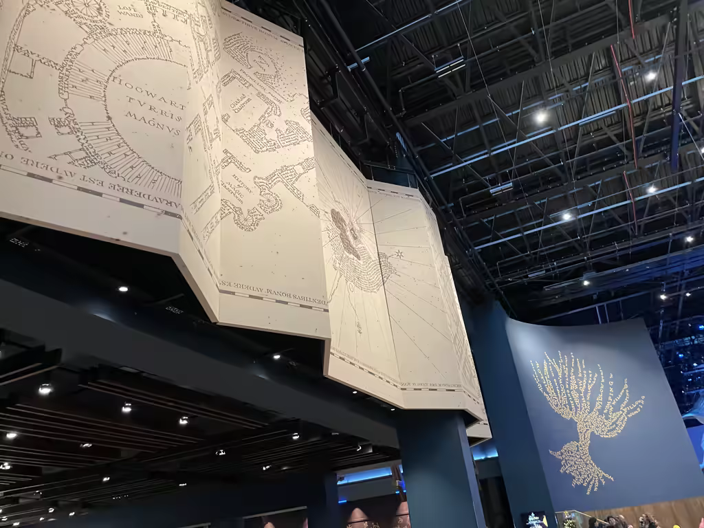 Large overhead map of Hogwarts and a Whomping Willow wall display at Warner Bros. Studio Tour London.