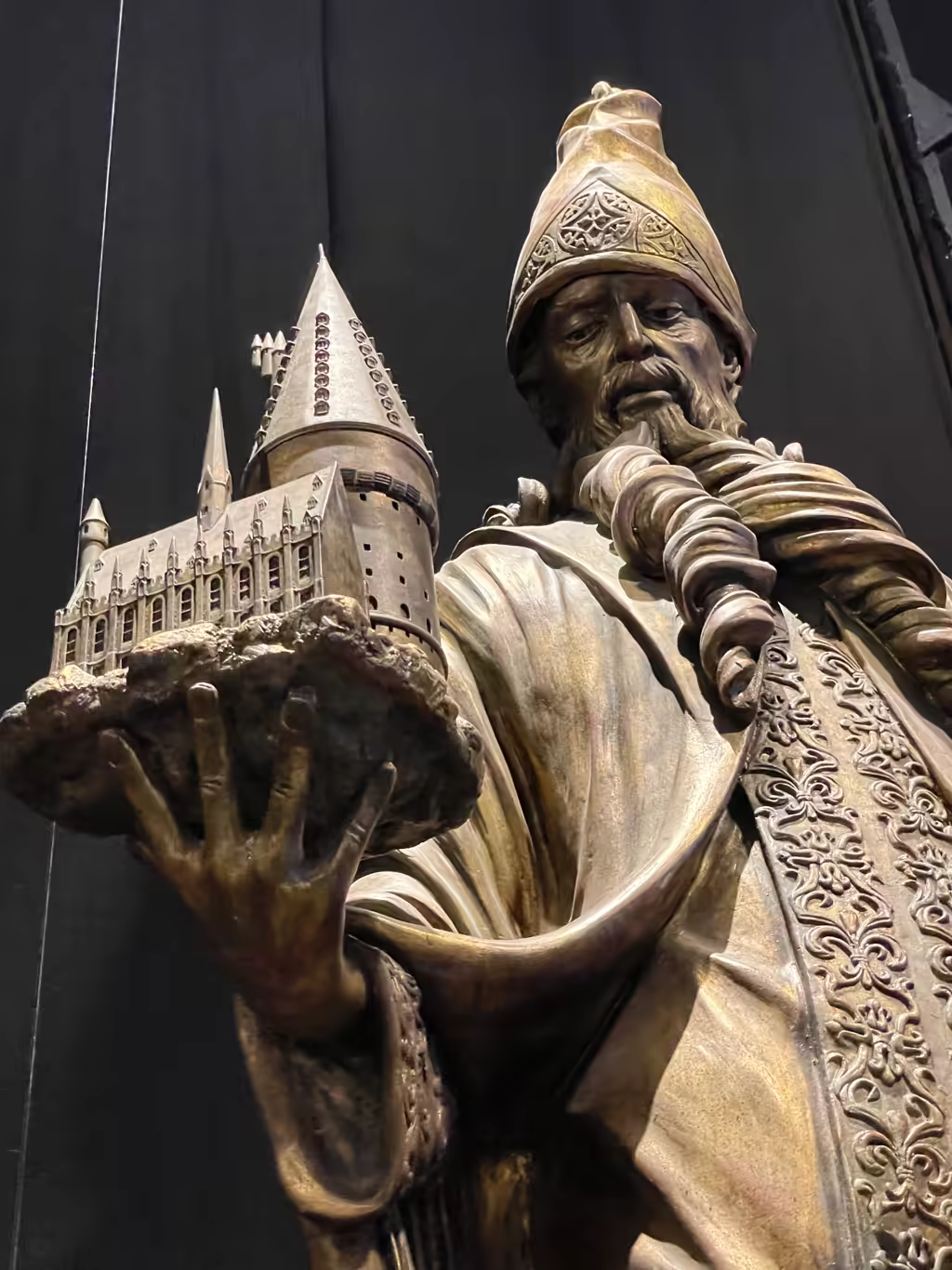 Marvel at the impressive statue of Salazar Slytherin holding a model of Hogwarts during your visit.