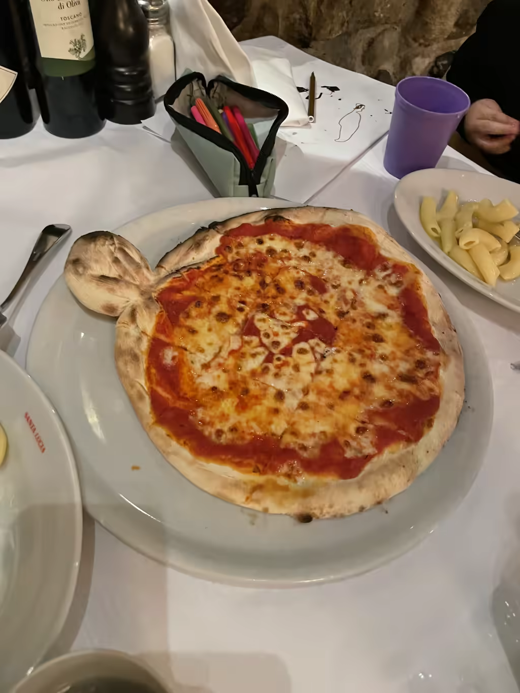 A whimsical pizza shaped like a head served on a white plate at Santa Lucia restaurant in Zurich.