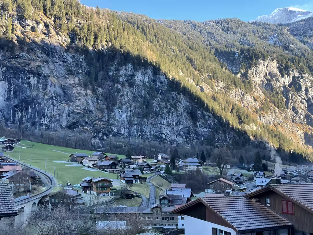 Dramatic granite peaks tower over the peaceful village of Lauterbrunnen, a perfect snowy mountain escape.