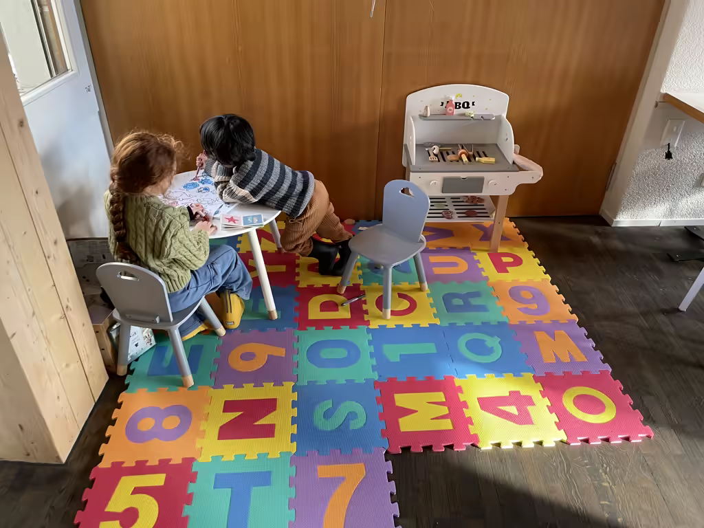 Children playing at a small table in a family-friendly hotel in Spiez, Switzerland.