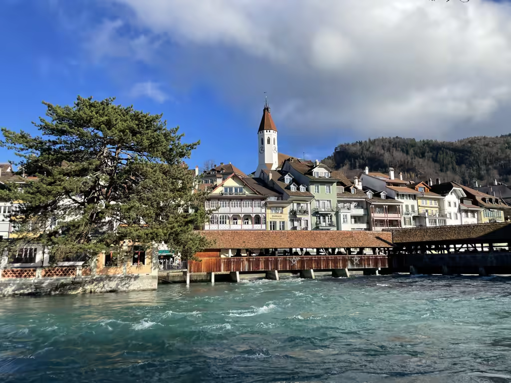 Wooden bridge over the Aare River with the historic Thun Church skyline in Bernese Oberland, Switzerland