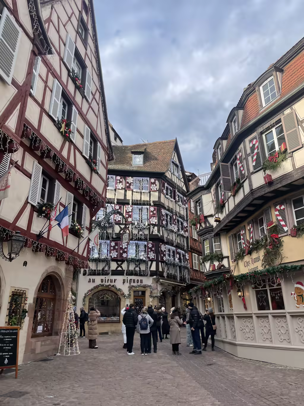 Half-timbered buildings decorated for Christmas in the historic center of Colmar, France.
