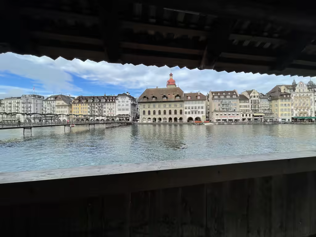 View of Lucerne’s historic buildings and the Reuss river from the covered Chapel Bridge.