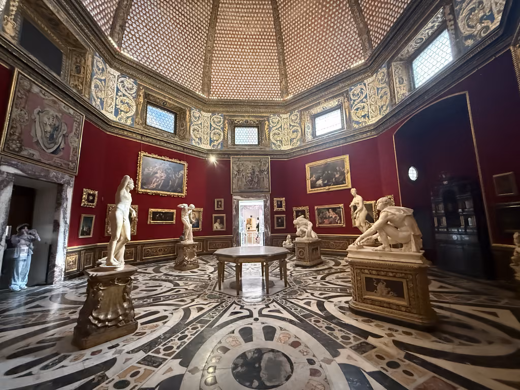 Statues and paintings inside the octagonal Tribune room of the Uffizi Gallery in Florence.
