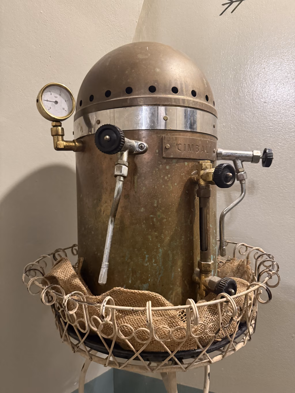 Vintage Cimbali copper espresso machine displayed in a Genoa cafe.