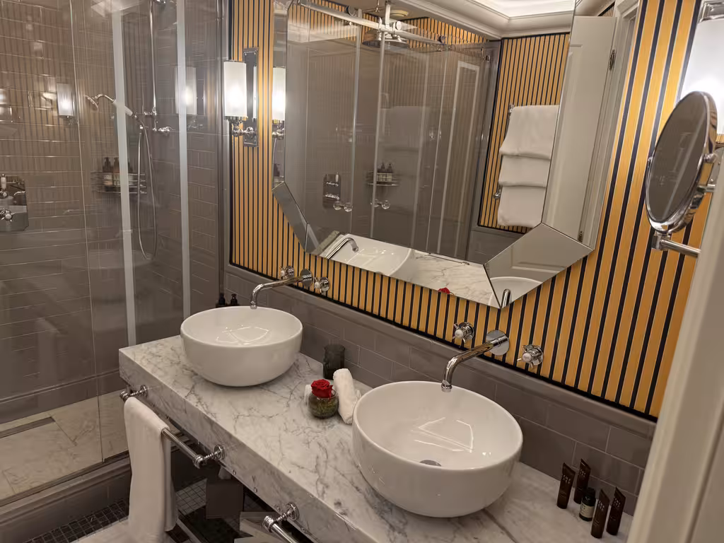 The dual marble vanities at Il Tornabuoni feature sleek, modern fixtures perfect for refreshing in Florence.