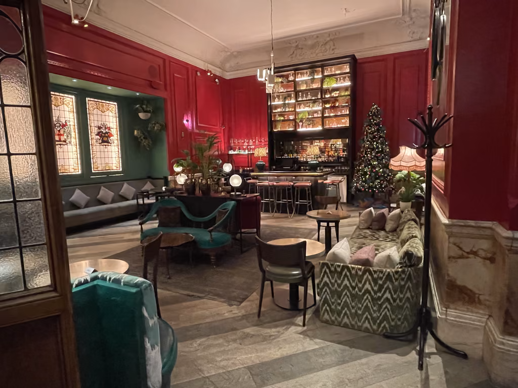 Enjoy a sophisticated evening lounge experience featuring festive holiday decor at a classic London hotel.