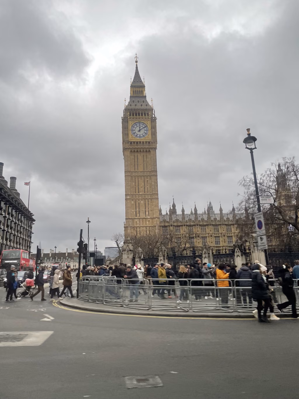 Iconic Big Ben towers over the bustling crowds near Parliament Square on a chilly London afternoon.