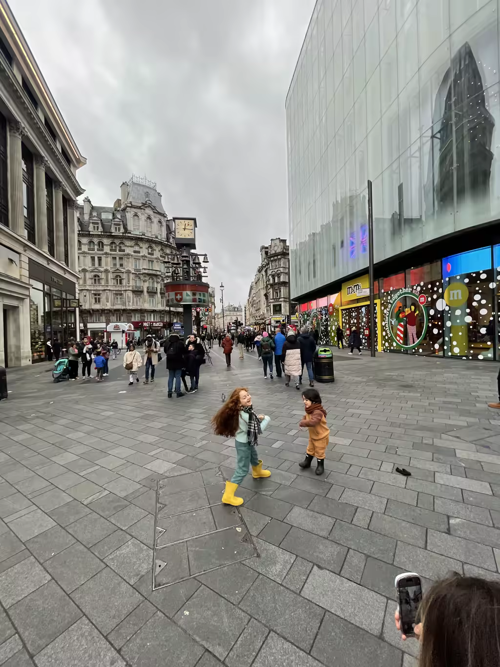 Little ones dance with joy outside the iconic M&M's World in London’s bustling Leicester Square.