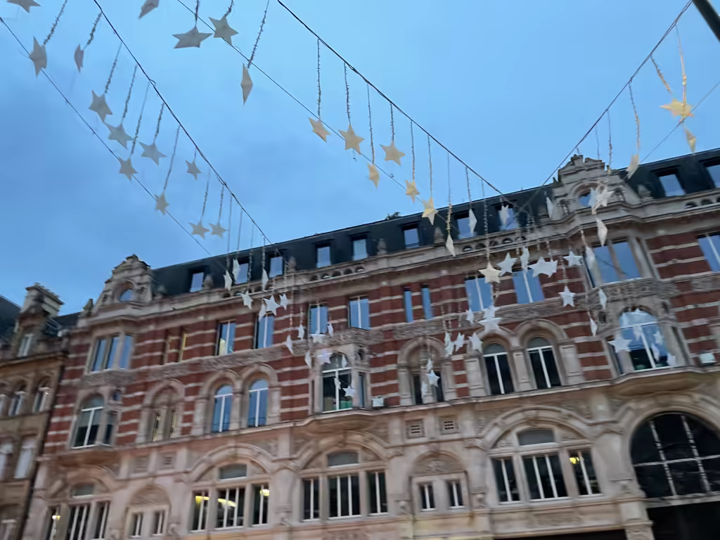 Holiday cheer fills the air with festive star decorations hanging above London's historic shopping streets.