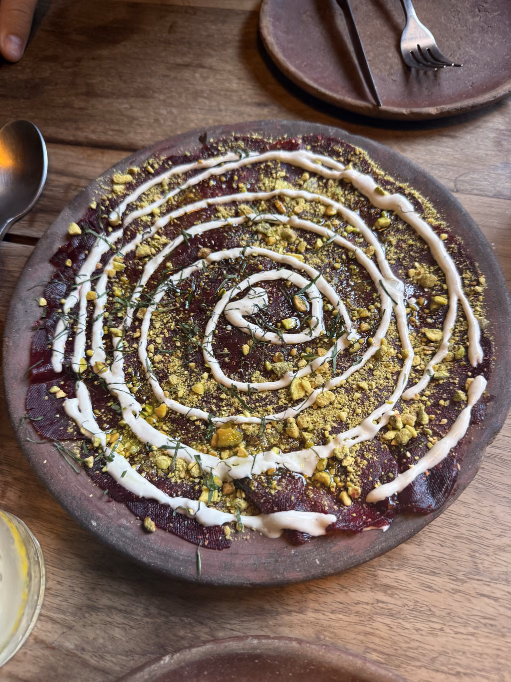 Savor thin slices of beet carpaccio drizzled with crema and crushed pistachios at a local eatery.