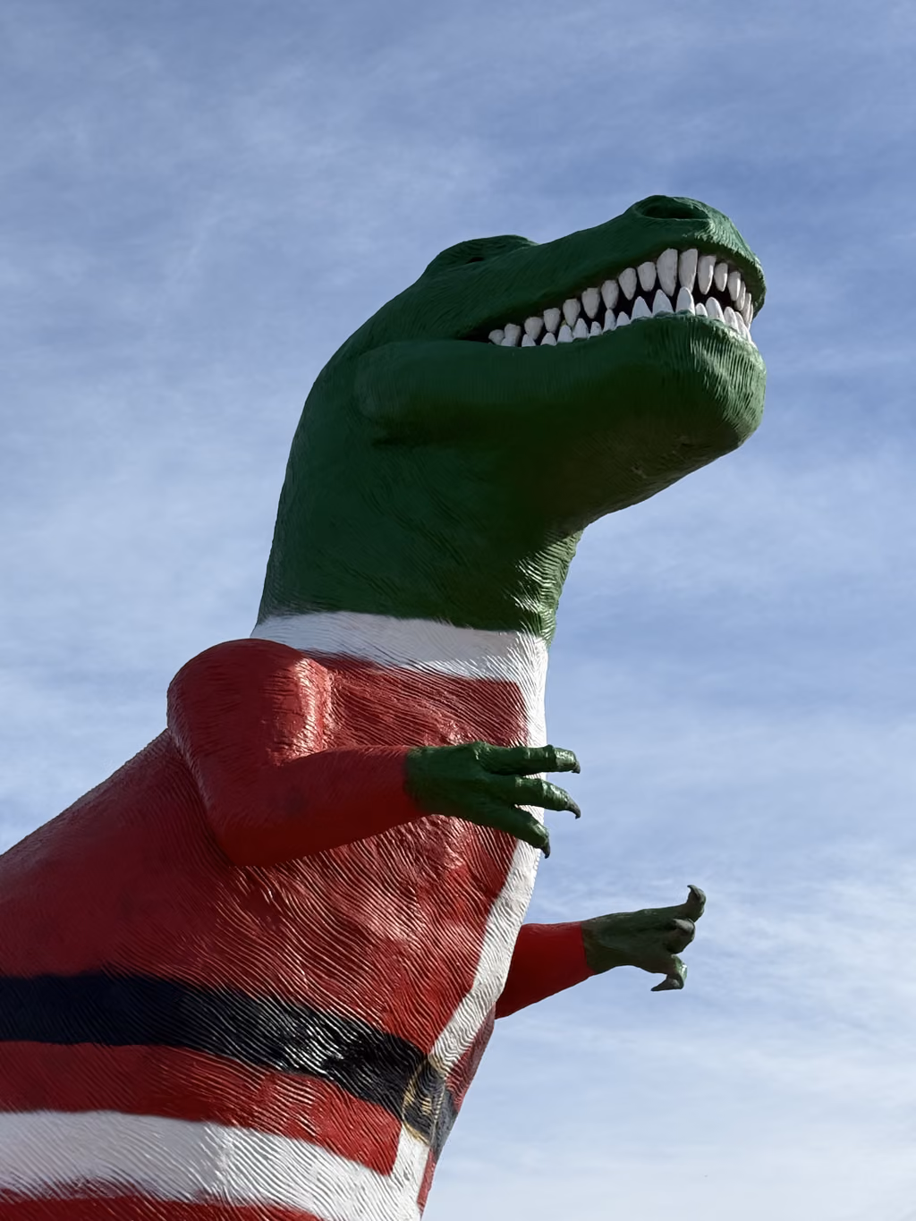 Giant T-Rex statue at Cabazon Dinosaurs near Palm Springs wearing a Santa suit.