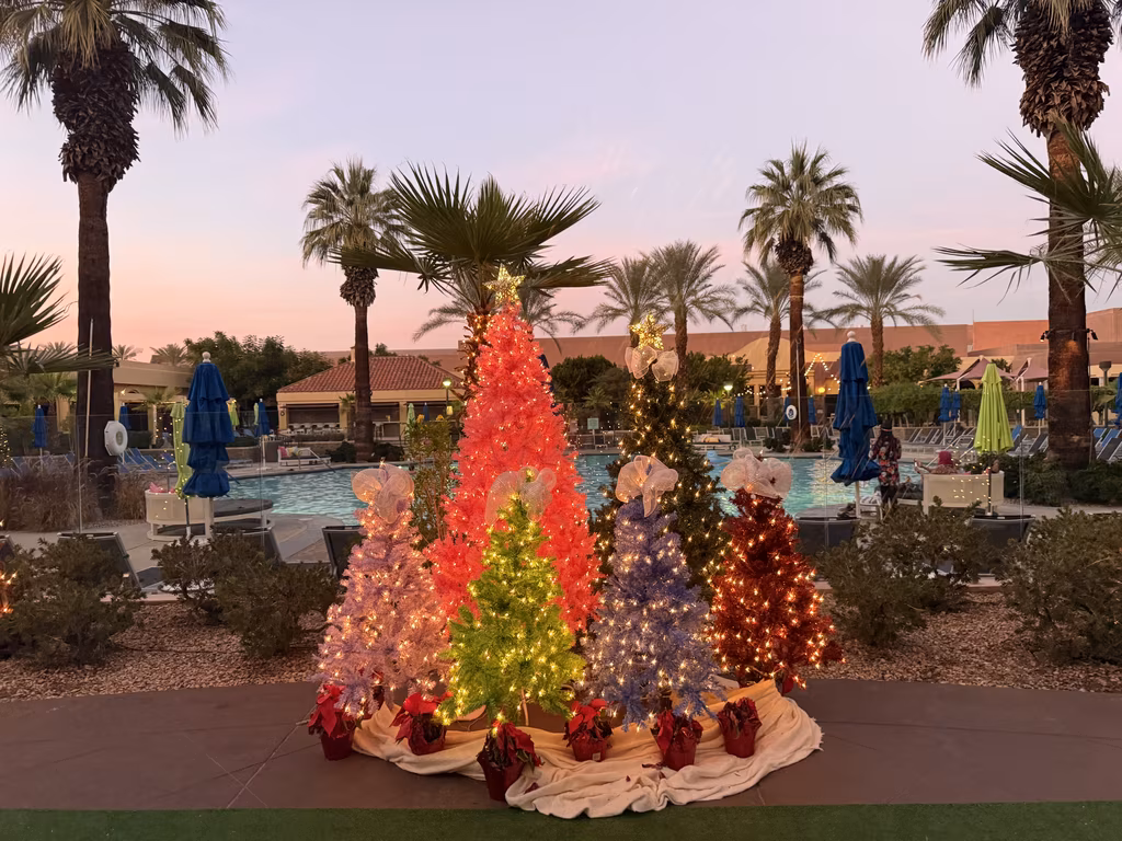 Colorful holiday trees illuminate the poolside deck at the Renaissance Palm Springs for festive evening vibes.