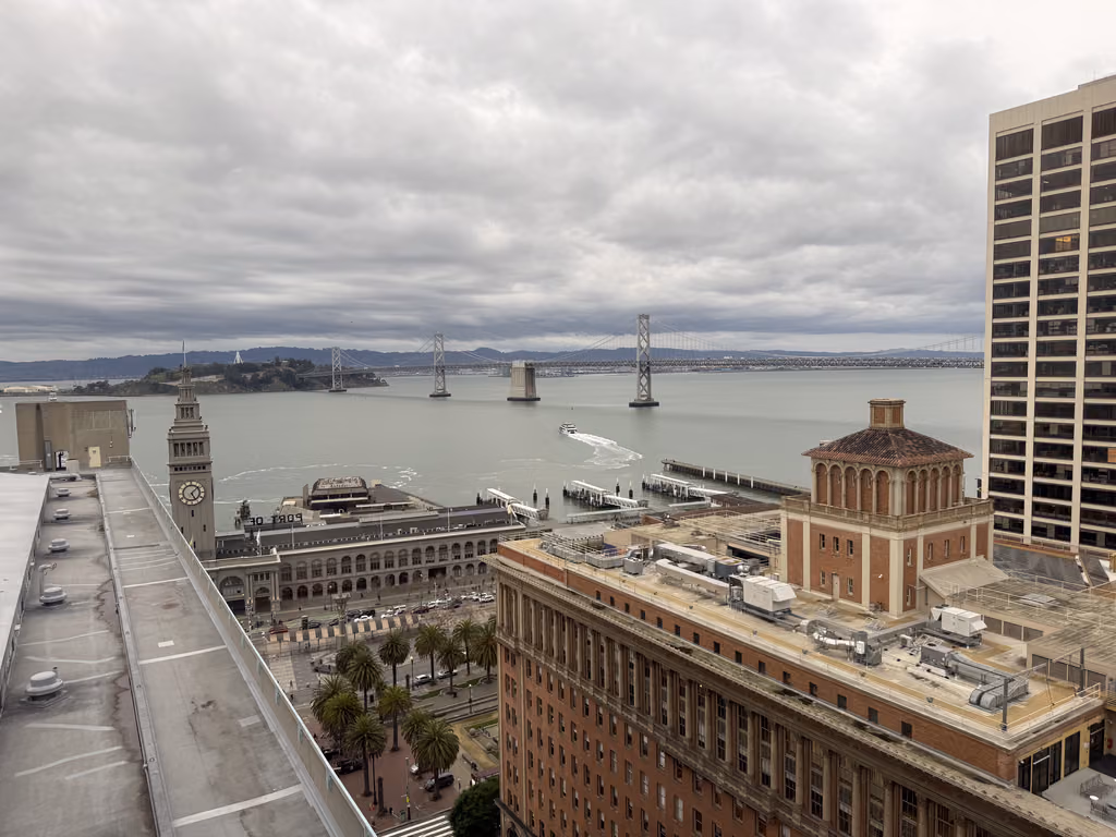 View of the San Francisco Ferry Building and Bay Bridge from a high-rise building.
