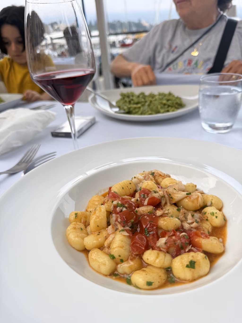 Gnocchi and red wine on a waterfront restaurant table in Santa Margherita Ligure.