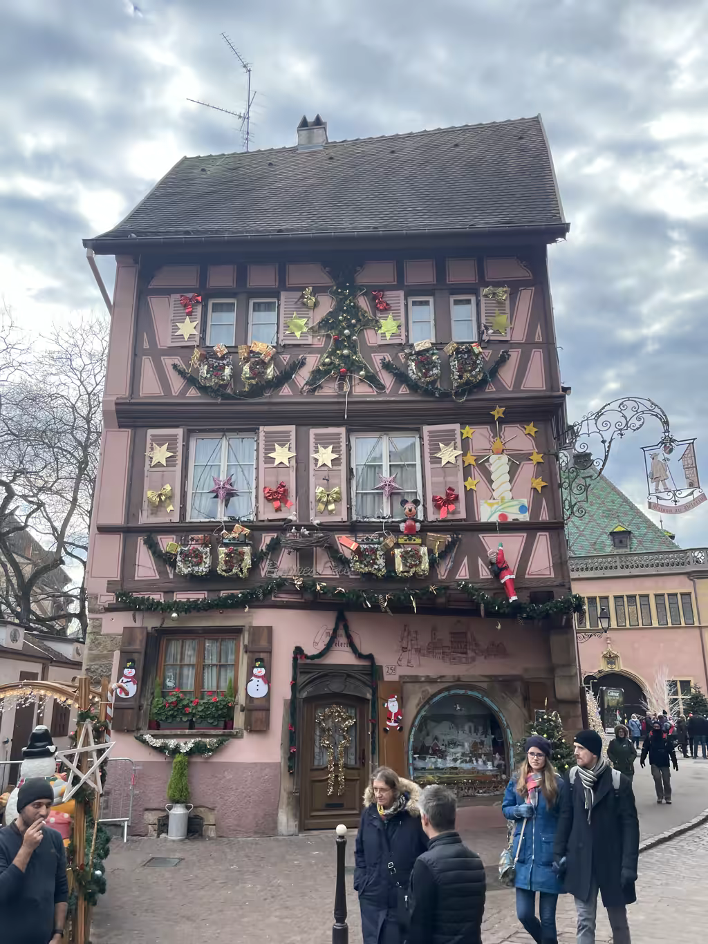 The charming Maison des Têtes in Colmar showcases festive, elaborate holiday decorations during the Christmas season.