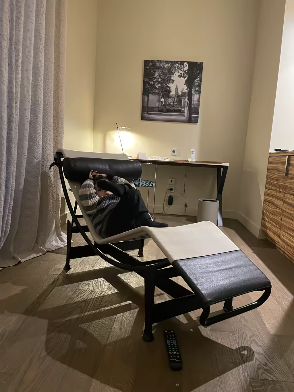 A child resting on a modern lounge chair inside a comfortable hotel room after visiting Strasbourg's Christmas markets.