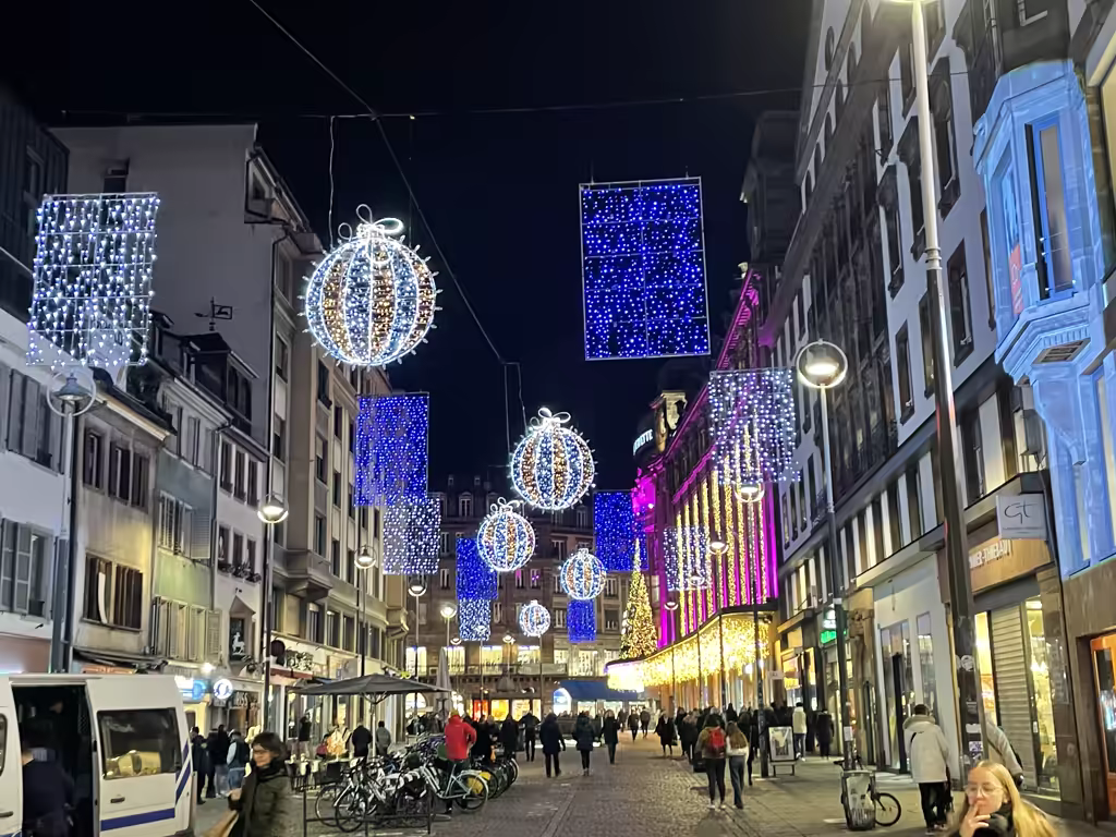 Experience the magical glow of Strasbourg's illuminated streets as festive Christmas decorations light up the evening.