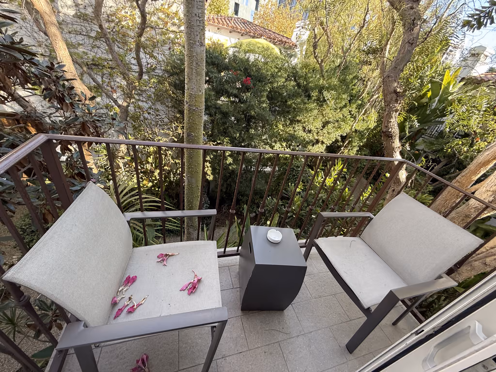Enjoy a quiet, lush morning coffee on your private balcony overlooking the hotel's garden oasis.